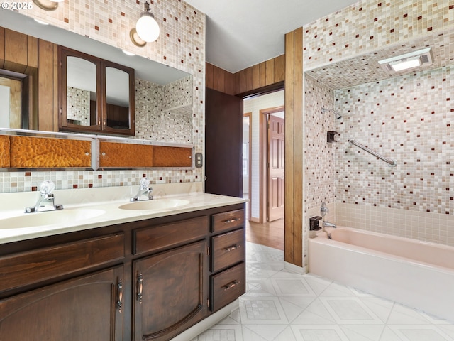 bathroom featuring a sink, tasteful backsplash, double vanity, and shower / washtub combination
