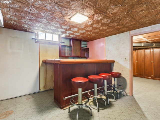 bar featuring an ornate ceiling, a dry bar, and tile patterned floors