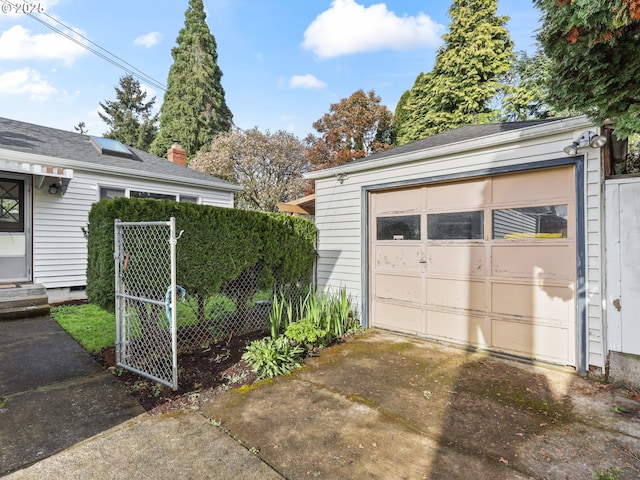garage with fence and driveway