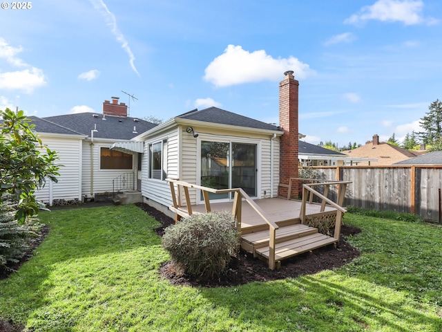 rear view of house with a chimney, a wooden deck, fence, a yard, and entry steps