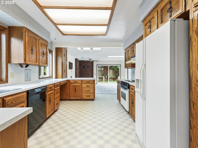 kitchen with ceiling fan, brown cabinets, light countertops, a peninsula, and white appliances