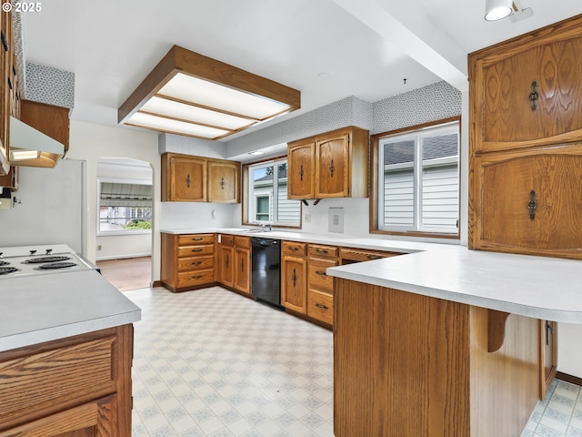 kitchen with brown cabinets, light countertops, arched walkways, black dishwasher, and light floors
