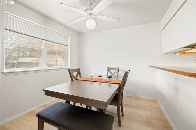 dining room featuring a ceiling fan, light wood-type flooring, and baseboards