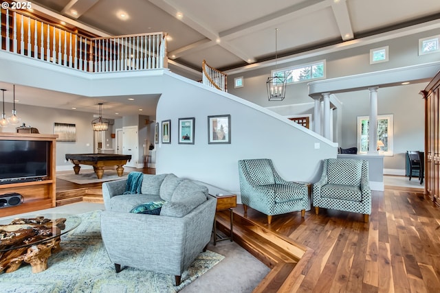 living area featuring stairs, billiards, coffered ceiling, and wood finished floors