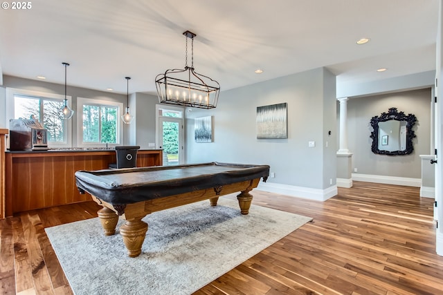 playroom with a wealth of natural light, decorative columns, wood finished floors, and recessed lighting