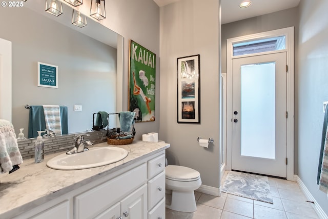 bathroom featuring tile patterned flooring, baseboards, vanity, and toilet