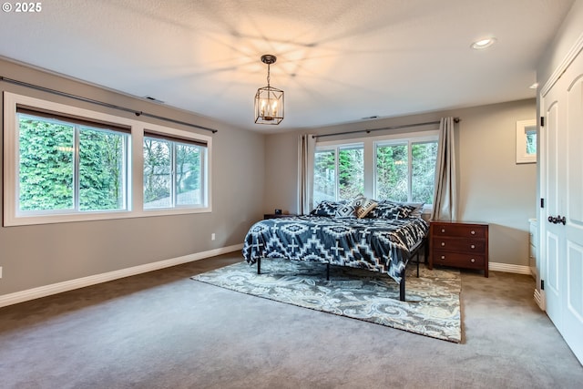 carpeted bedroom with a chandelier, recessed lighting, visible vents, and baseboards