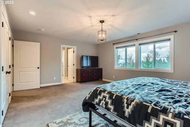 bedroom with baseboards, a chandelier, and light colored carpet