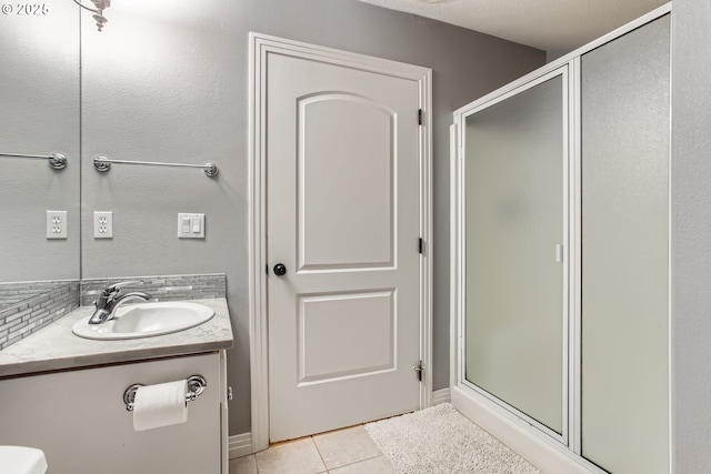 bathroom with toilet, tile patterned flooring, vanity, and a shower stall