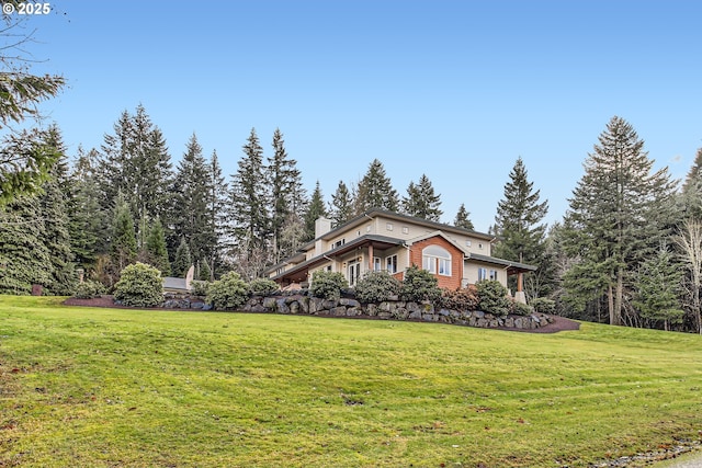 view of property exterior featuring a lawn and a chimney