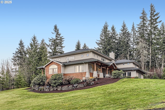 view of front of house featuring a chimney and a front yard