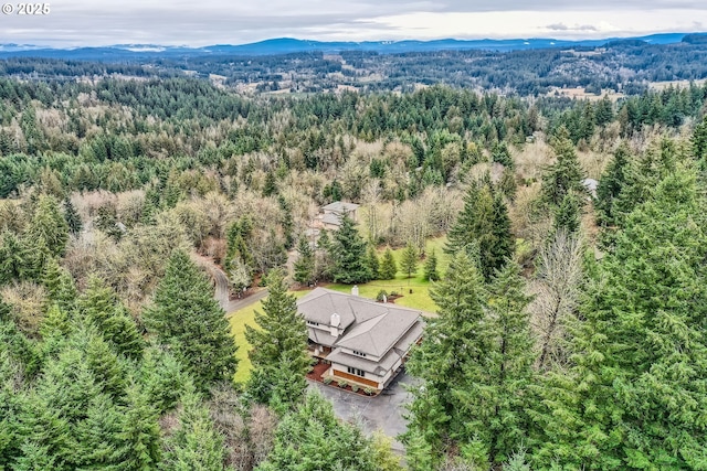 birds eye view of property featuring a wooded view and a mountain view