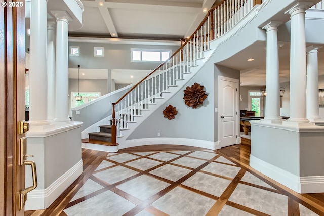 interior space with baseboards, a healthy amount of sunlight, and ornate columns