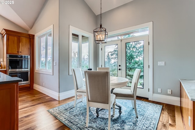 dining room featuring vaulted ceiling, light wood finished floors, and a wealth of natural light