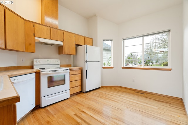 kitchen with light wood-style flooring, visible vents, white appliances, brown cabinets, and under cabinet range hood