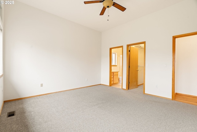 unfurnished bedroom with connected bathroom, baseboards, visible vents, and light carpet