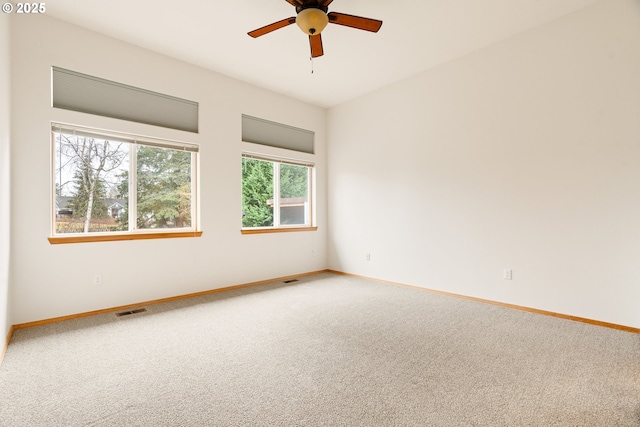 spare room with carpet flooring, baseboards, and visible vents