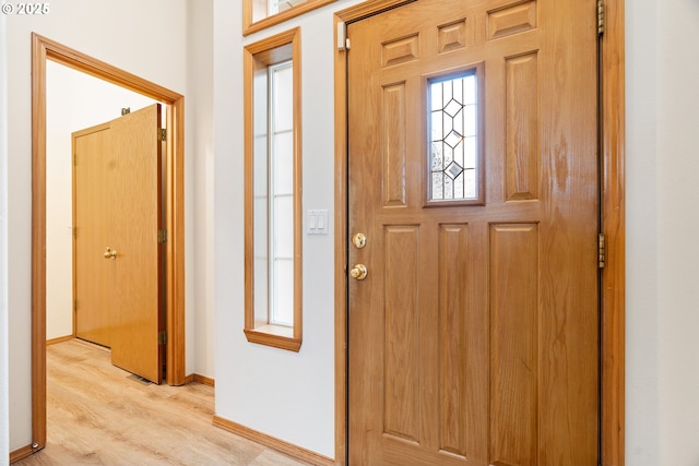 entrance foyer with baseboards and light wood finished floors