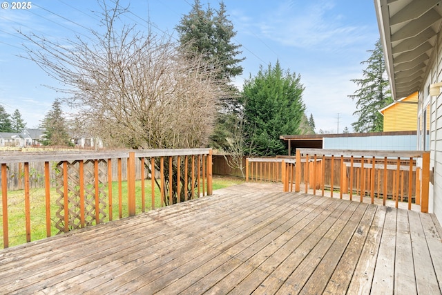 wooden terrace with a lawn and a fenced backyard