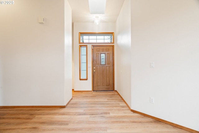 foyer entrance with light wood-style flooring and baseboards