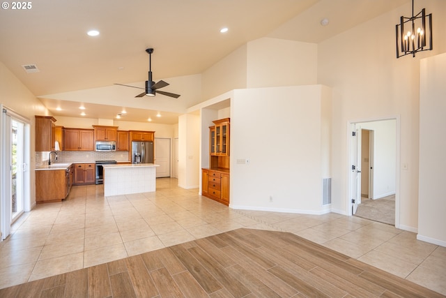 kitchen with visible vents, ceiling fan with notable chandelier, high vaulted ceiling, light countertops, and appliances with stainless steel finishes