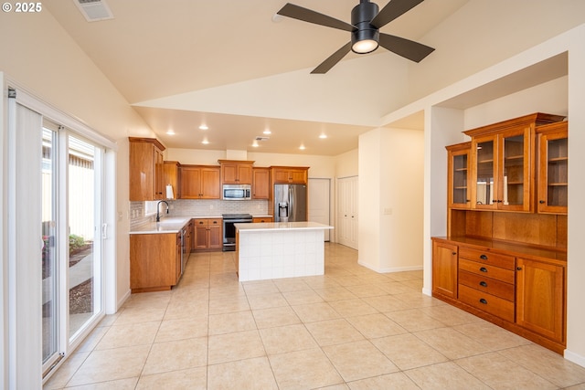 kitchen featuring light countertops, decorative backsplash, brown cabinetry, and stainless steel appliances