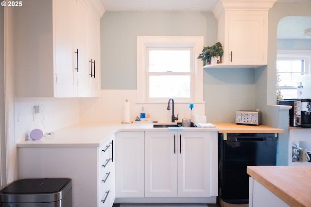 3710 SE 86th Ave, Portland, OR 97266 - kitchen with black dishwasher, white cabinets, a sink, and light countertops