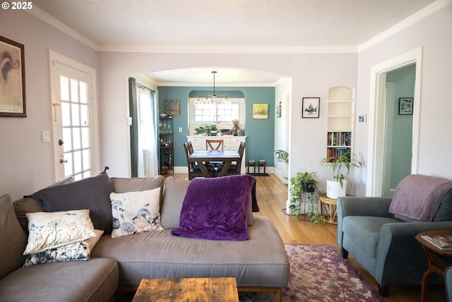 3710 SE 86th Ave, Portland, OR 97266 - living area with arched walkways, light wood-style flooring, crown molding, a chandelier, and baseboards