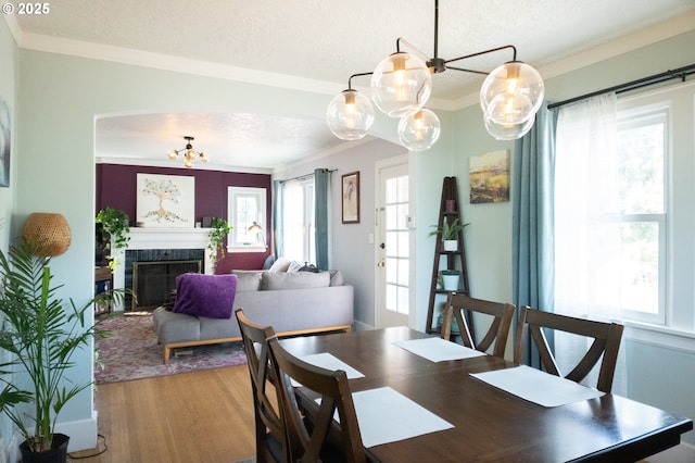 3710 SE 86th Ave, Portland, OR 97266 - dining area featuring a textured ceiling, wood finished floors, a chandelier, ornamental molding, and a tile fireplace