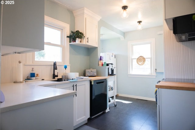 3710 SE 86th Ave, Portland, OR 97266 - kitchen featuring white cabinetry, a sink, black dishwasher, and baseboards