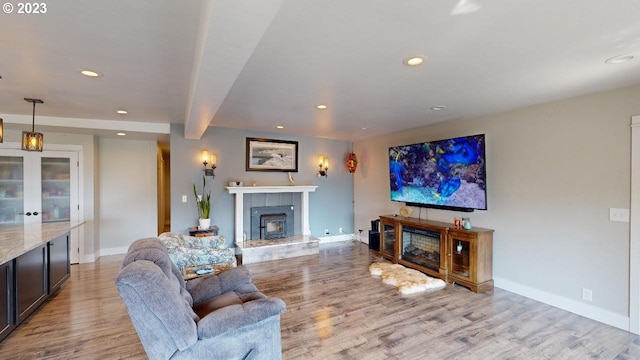 97997 Olsen Ln, Brookings, OR 97415 - living room with a tiled fireplace, recessed lighting, wood finished floors, baseboards, and beam ceiling