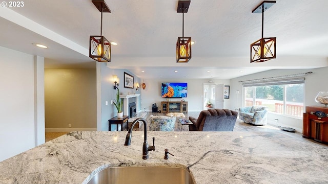 97997 Olsen Ln, Brookings, OR 97415 - kitchen featuring a sink, recessed lighting, light stone countertops, a fireplace, and hanging light fixtures