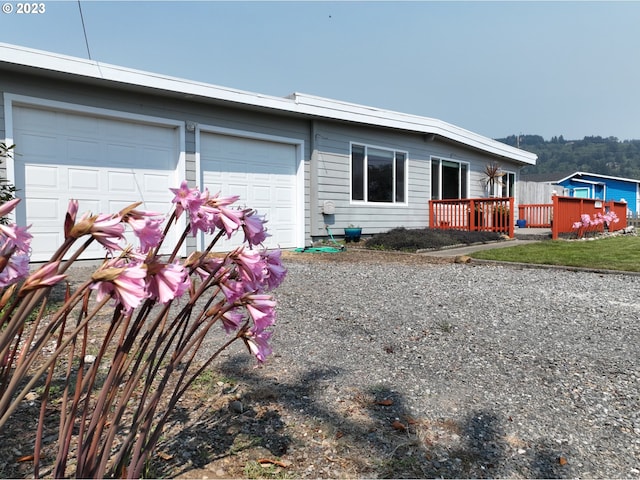 97997 Olsen Ln, Brookings, OR 97415 - view of front of house featuring an attached garage and a wooden deck