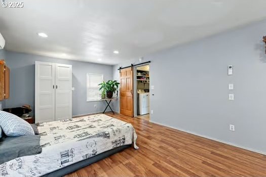 4664 Concord St, Eugene, OR 97402 - bedroom with a barn door, a closet, wood finished floors, and recessed lighting