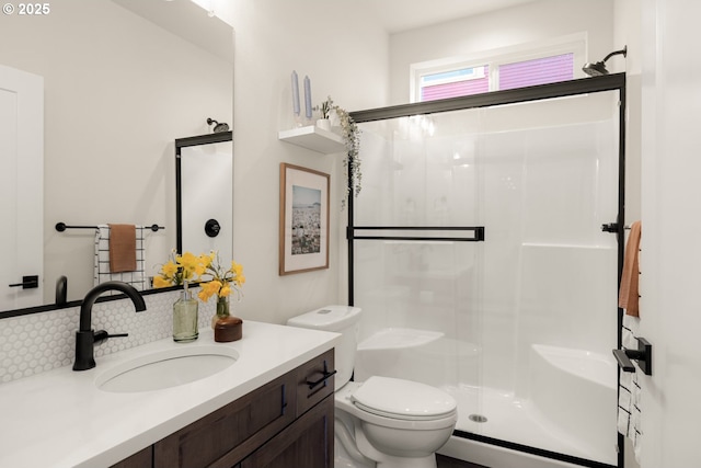 full bathroom with vanity, a shower stall, toilet, and tasteful backsplash