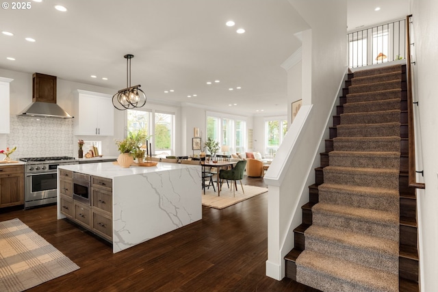 kitchen featuring backsplash, high end stainless steel range oven, dark wood-type flooring, and wall chimney exhaust hood