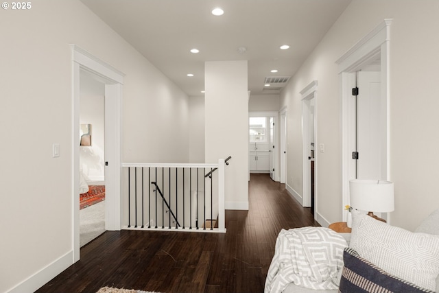 hallway featuring visible vents, baseboards, an upstairs landing, recessed lighting, and wood finished floors