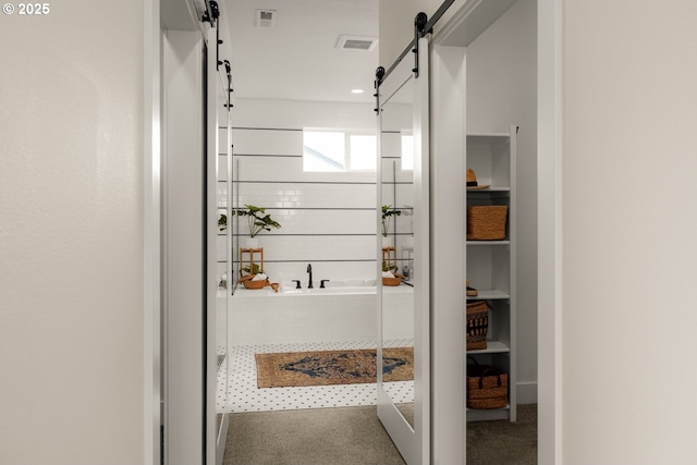 bathroom with visible vents and a tile shower