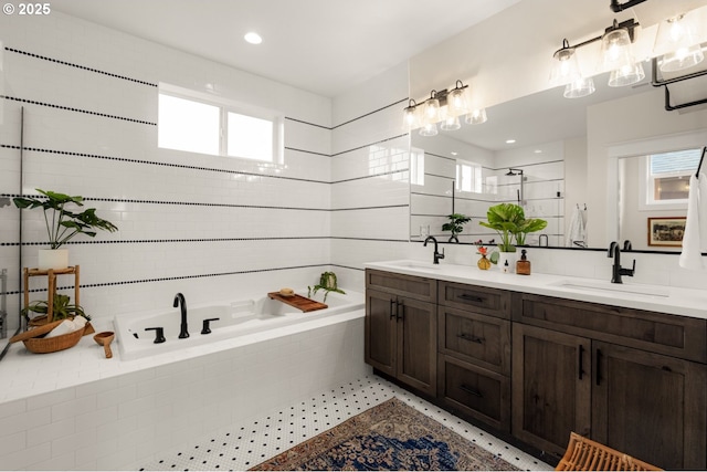 full bath with a bath, an enclosed shower, double vanity, and a sink