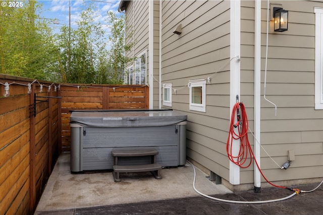 exterior space featuring fence and a hot tub