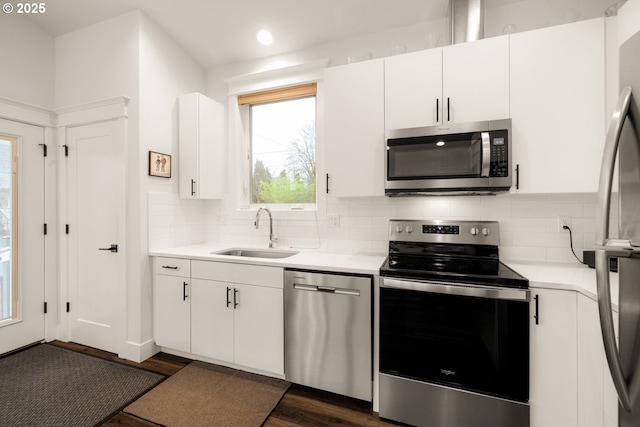 kitchen with a sink, stainless steel appliances, decorative backsplash, and light countertops