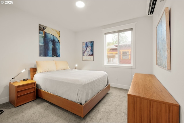 bedroom featuring light carpet, a wall mounted air conditioner, and baseboards