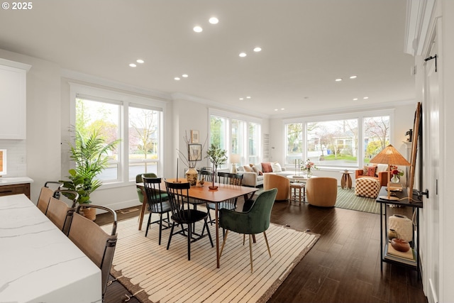 dining room with plenty of natural light, dark wood-style floors, and crown molding