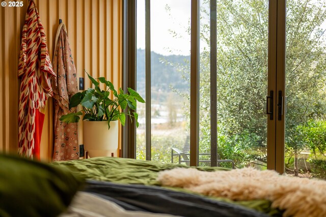 bedroom with access to outside, a high ceiling, and wood finished floors