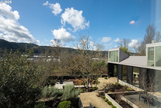 view of yard featuring a garden, a patio, and a mountain view