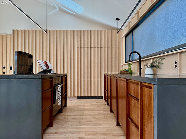 bar featuring lofted ceiling, light wood-style floors, and hanging light fixtures