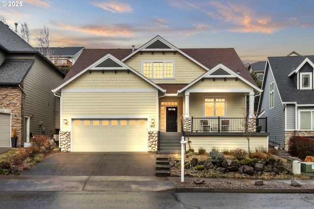craftsman inspired home featuring stone siding, concrete driveway, covered porch, and an attached garage