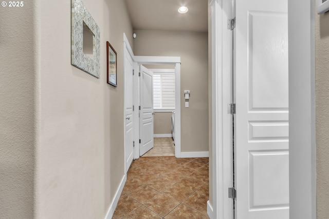 corridor with light tile patterned floors, recessed lighting, and baseboards