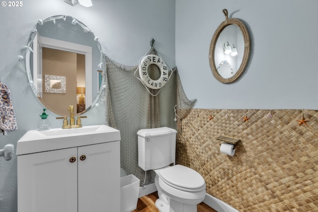 bathroom with toilet, wood finished floors, and vanity