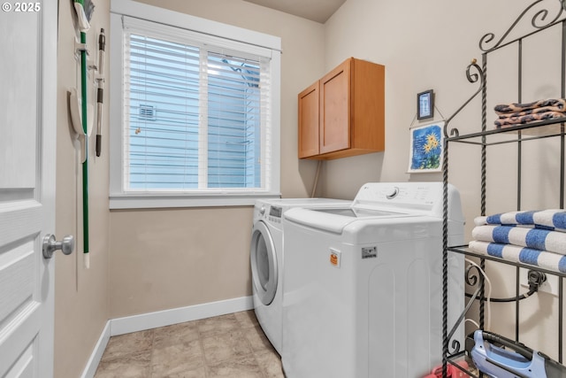 laundry room with washer and dryer, cabinet space, and baseboards